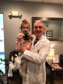 Dr Sharara holding their toddler daughter